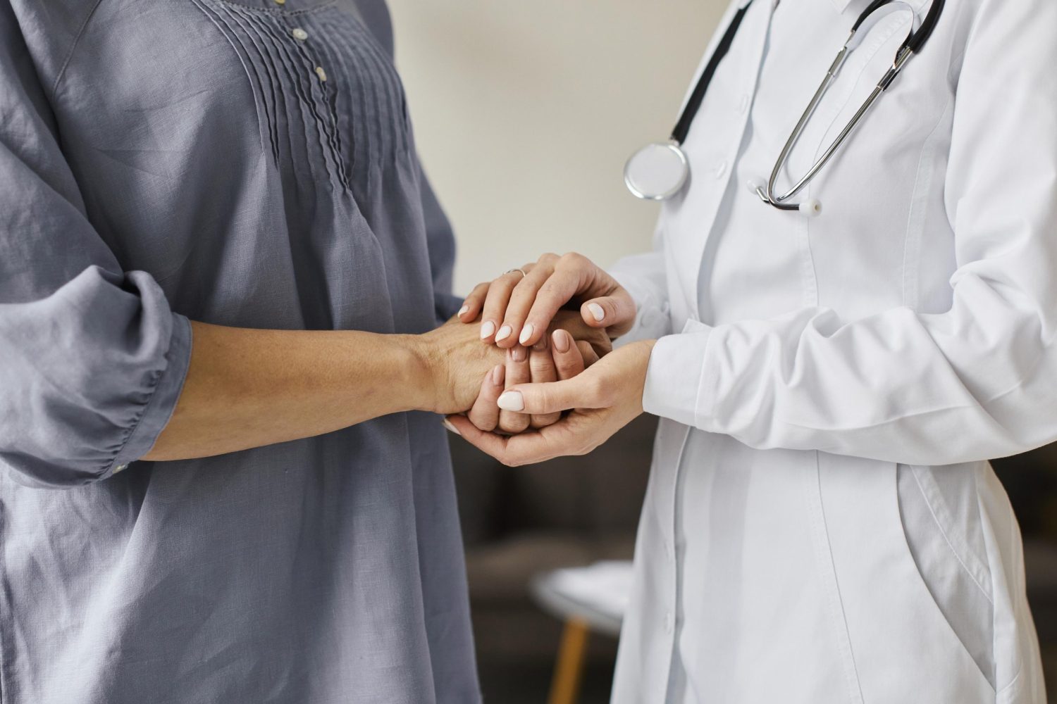 Doctor holding hand of an elderly female patient