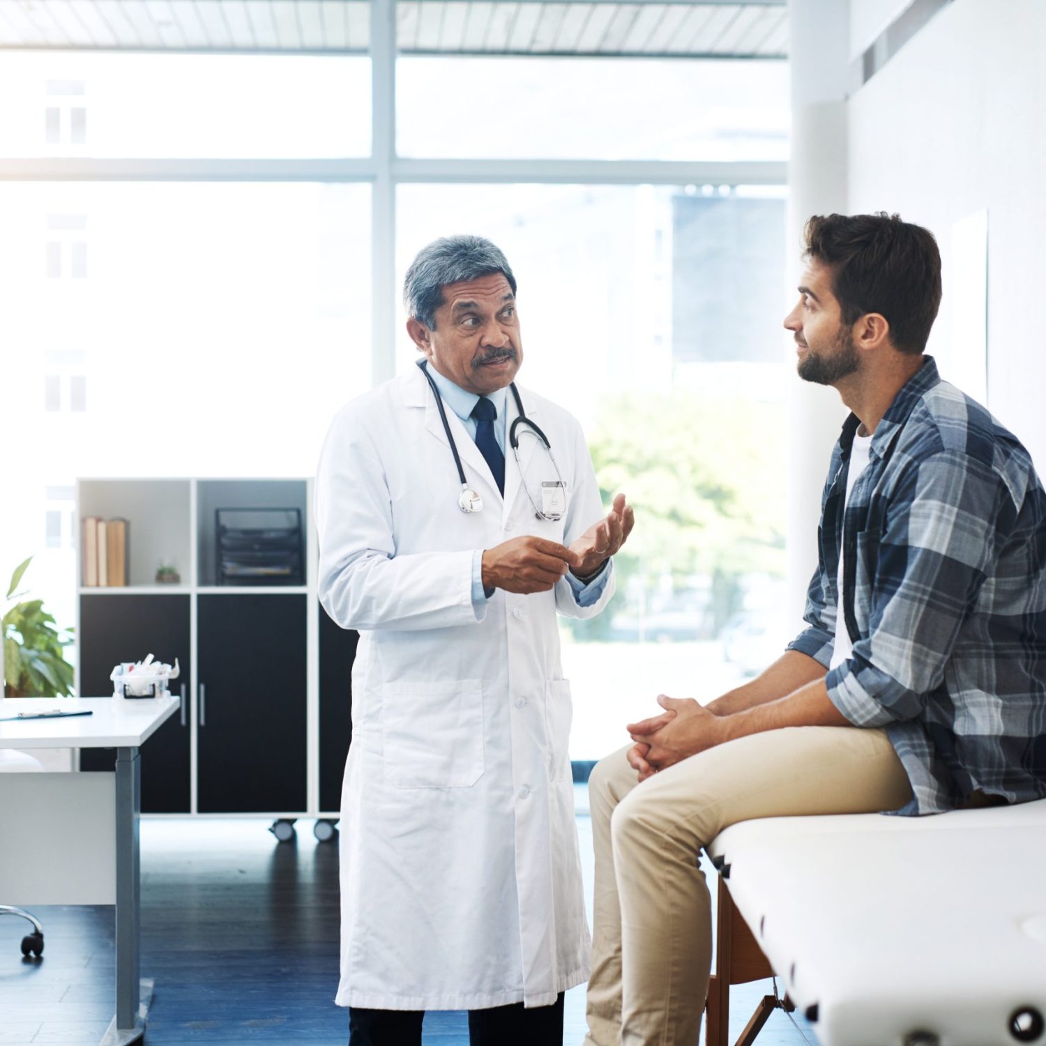 Mature male doctor talking to a male patient